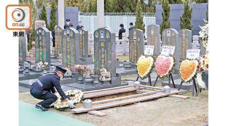 遺體下葬後關員獻上花圈。（袁志豪攝）