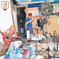 其中一間木屋前擺放多輛單車，有男子正忙於修理。