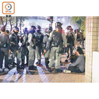 有示威者被制服後坐於地上。（李志湧攝）