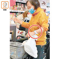 紅磡<br>戴上手帶（紅圈示）中年婦在超市購物。