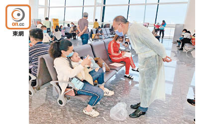 湖北<br>曾國衞在武漢天河國際機場，慰問準備返港的市民及幼童。