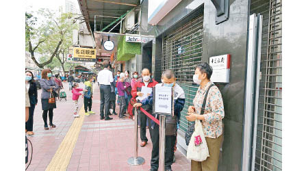 澳門市民昨在銀行門口排隊領取消費卡。