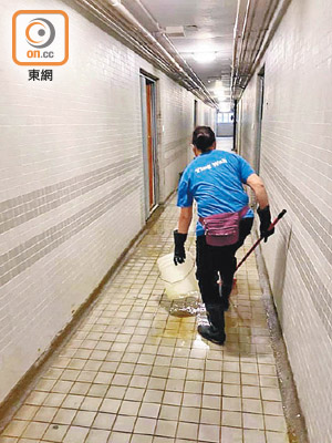 清潔工在走廊進行清理糞便。