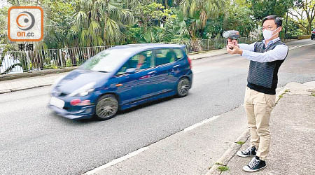 楊哲安喺路邊探測車輛落山嘅車速。