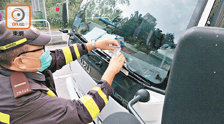 警員對違泊車輛發出告票。