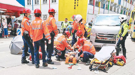 救護員替兩名傷者包紮及急救。