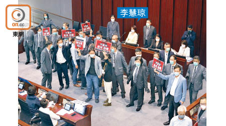 李慧琼昨日坐上主席位，一眾泛民議員舉標語表示不滿。（何天成攝）