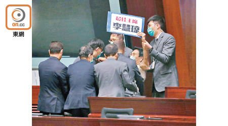 朱凱廸因展示具侮辱性示威牌被逐離會議廳，保安員將他抬走。