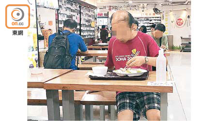 身穿紅衣的中年男子，在深水埗一商場的公共食堂吃「二手飯」。