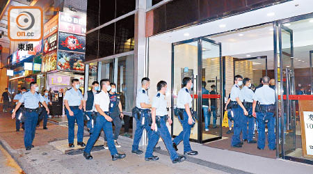 多名軍裝警員進入金馬倫道一幢商廈搜查。（沈厚錚攝）