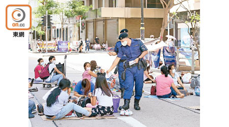 海關特務警察昨午在中環一帶執法，呼籲市民不可多於四人一組聚集。（羅錦鴻攝）