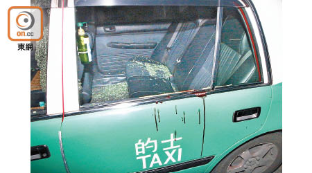涉案的士車窗被扑至碎裂，車身留有血漬。（張福宏攝）