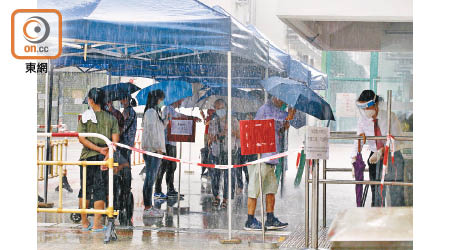 旺角：市民昨天早上冒滂沱大雨等候檢測。（李志湧攝）