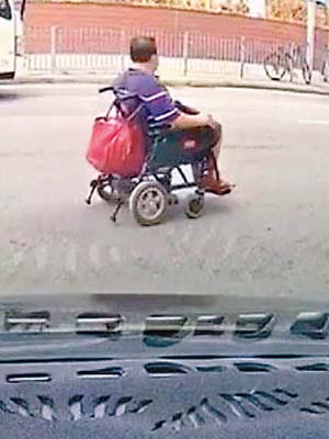 輪椅男一直在馬路行駛。