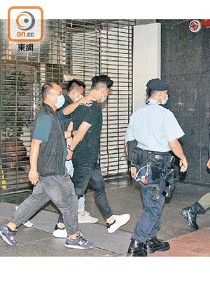 尖沙咀：其中一名被捕男子由警員押走。（何子輝攝）
