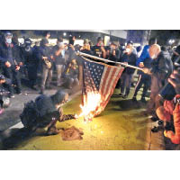 俄勒岡州：波特蘭示威者焚燒美國國旗。（美聯社圖片）