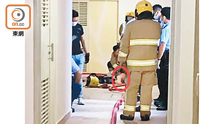 救援人員在走廊為救出的一名傷者（紅圈示）進行急救。
