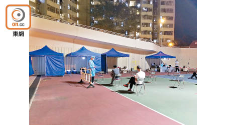 數名市民傍晚到廣福邨廣惠樓旁的排球場輪候檢測。（馬竟峯攝）