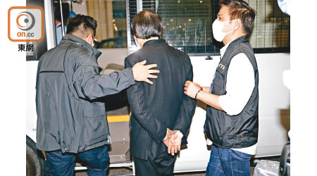 反手上手銬：上海仔（中）雙手被反鎖手銬押解至機場警署。
