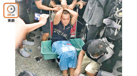 《環球時報》記者付國豪（中）前年8月被佔據香港機場的示威者禁錮和襲擊。
