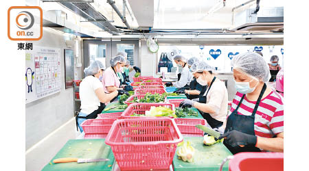 義工和職員密鑼緊鼓地分類、清洗和切割收集得來的蔬菜。