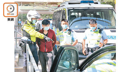 被捕男子被警員押往搜車。（林耀康攝）