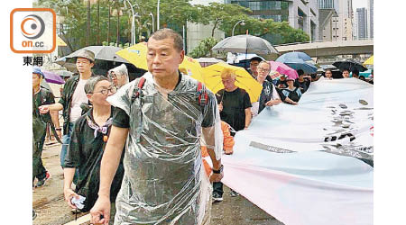 黎智英等人案發時手持橫額站在遊行隊頭。