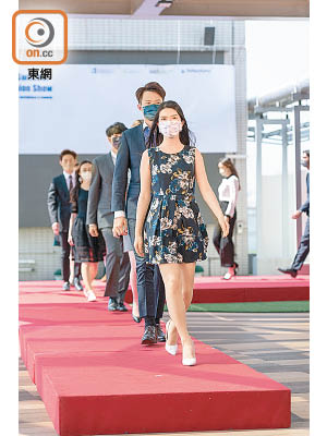 學生模特兒在天橋走秀示範適合上班的衣飾穿搭。