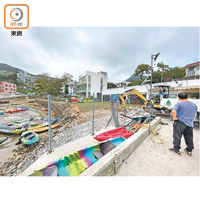 工人在僭建碼頭進行還原工程，用挖泥車將石屎搬到車斗。