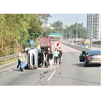 其他駕駛人士落車查看翻車女司機（箭嘴示）情況。