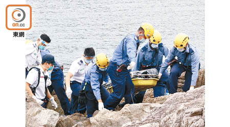 消防員將林永忠遺體抬離石灘。