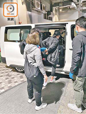 被捕女子由警員押上警方車輛。