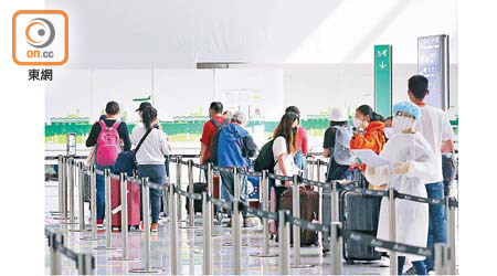 旅客按照工作人員指示進行登記檢測。（林耀康攝）