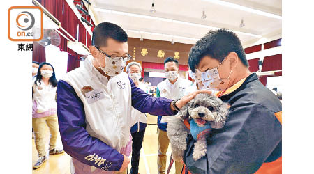 麥展豪（左）出席結業禮時與義工犬互動。