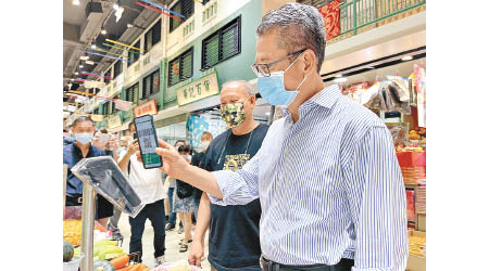 陳茂波到訪不同地區的街市，嘗試以電子支付工具消費。