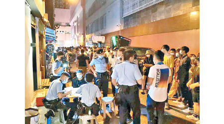 銅鑼灣：警方向在場人士發出告票。