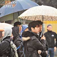 現場不少同學撐着雨傘打氣，用熱情對抗寒冬。