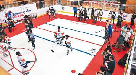 禮堂內建立嘅仿真溜冰場，學員正在示範冰球技巧。