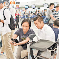 球迷在機場「集郵」，捉住陳肇麒（右）玩自拍。