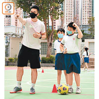 校方體育老師（左）循影片指示，教導同學足球技巧。